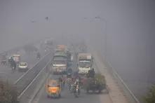 Street photo of people commuting amid smoggy conditions in Lahore, Pakistan on December 2, 2021