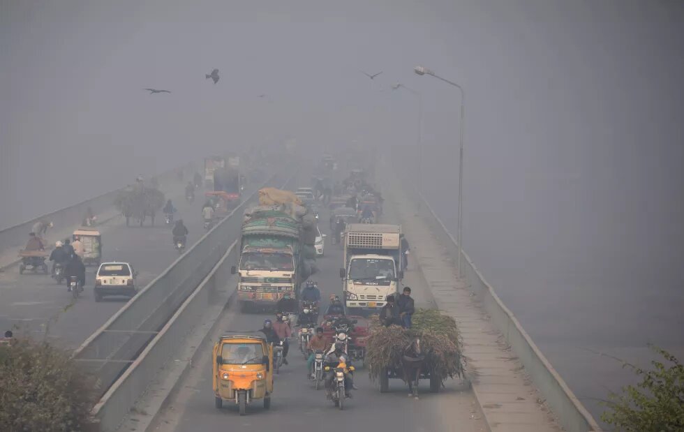 Street photo of people commuting amid smoggy conditions in Lahore, Pakistan on December 2, 2021