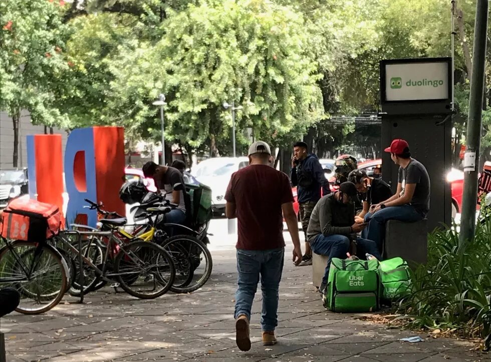 Foot and bike food-app workers waiting an order out of a mall